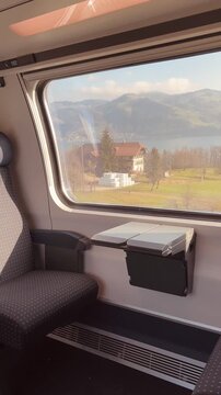 Scenic View of Swiss Lakes and Mountains from a Moving Train Window