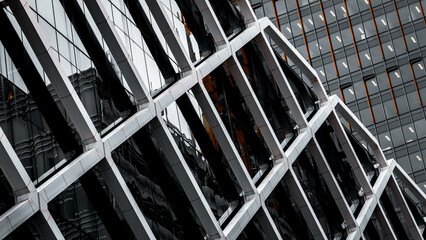 Architectural abstract. Generic modern building exterior in black and white with orange accents. Tubular framework over glass. © Rixie