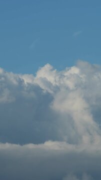 Clouds forming in a blue sky. 4K Vertical