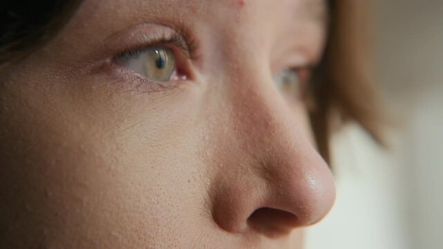 Big close up shot of young Caucasian girl with sleep deprivation squeezing her eyes shut and opening then after sleepless night