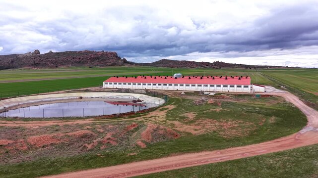 Aerial view of a modern swine production facility in Spain with livestock housing, ventilation stacks and slurry lagoon used for manure storage in intensive pork production systems