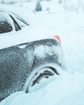 View of a car half-buried in deep, crisp snow, its dark form contrasting against the overwhelming white, a silent testament to the harsh winter, Bellefosse, Grand Est, France.