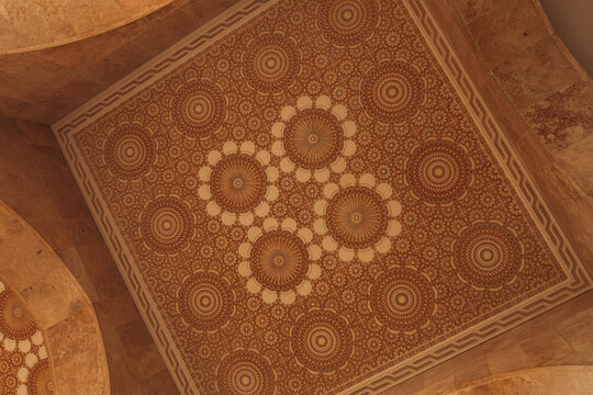 View of intricate geometric patterns dance across the ceiling, a symphony of ochre and cream, evoking the rich cultural heritage of Casablanca, Casablanca-Settat, Morocco.