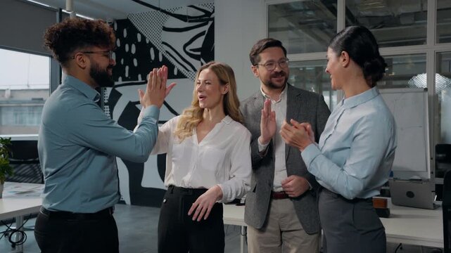 Four multiethnic business people team talking applauding giving high five partnership success group of employers happy talk teamwork cooperate achieve gesture applause in office multiracial workers