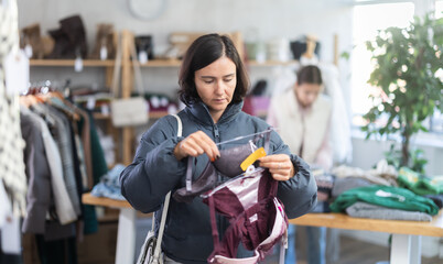 Seasonal trade sale, customer review at products in store and pick out clothes. Woman search and...