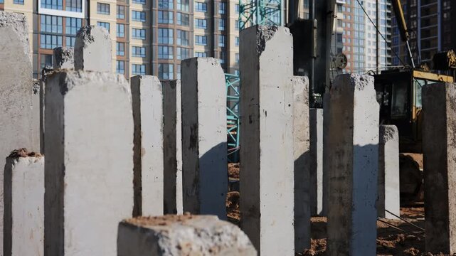 Concrete foundation piles at construction site with drilling rig