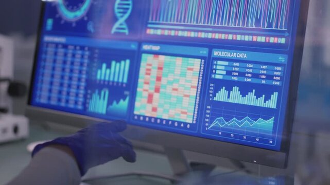 Female scientist in protective wear working in a medical research laboratory. Typing on a computer and examining the data