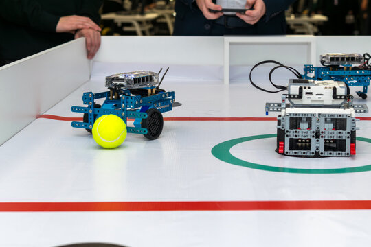 Students participating in a robot soccer competition with DIY programmable robots. controlled by robo football