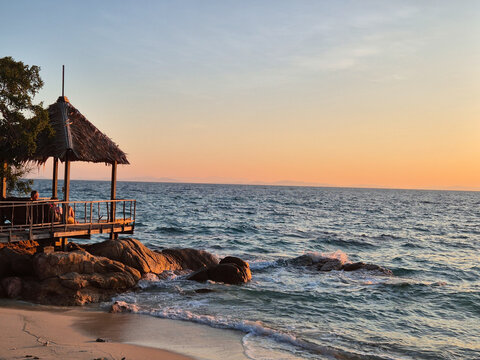 Relaxing sunset view from a tranquil beachside gazebo in Klaeng, Thailand