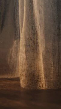 Vertical video: Swaying draped linen drifting in breeze at home over floor with mist and warm light