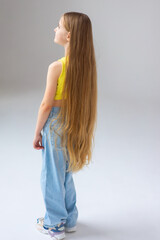 Fototapeta premium Happy little girl model with long blondie hair. Emotional, cheerful, joyful, cute, adorable caucasin girl posing in studio
