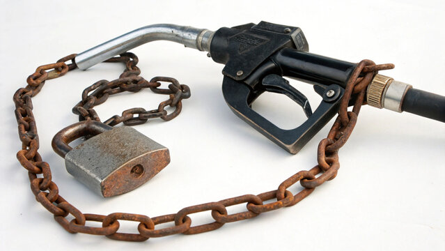 Rusty chain and padlock securing black fuel nozzle on white background symbolizing fuel restriction and control