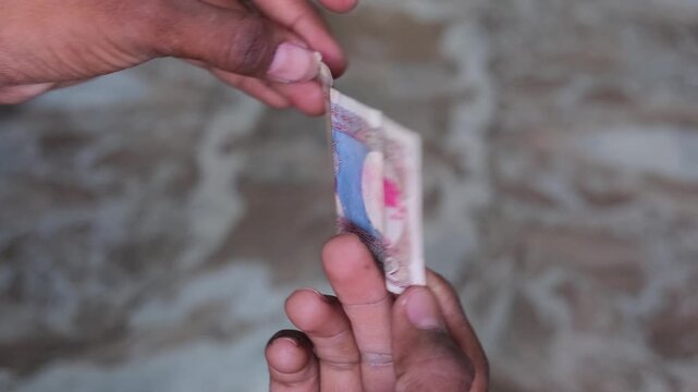 Hand holding an old 2 Rupee Indian banknote