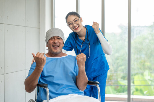 A male cancer patient in a wheelchair receives IV therapy while a female doctor offers care encouragement and updates on his test results providing support and discussing health progress
