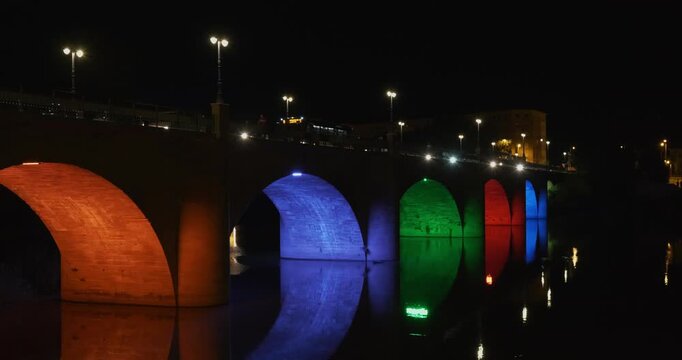 Traffic over a bridge illuminated with interchangeable colors by night, in Logro&ntilde;o, La Rioja, Spain
