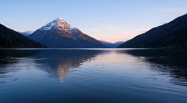 Serene mountain lake landscape with reflections on calm water at sunset