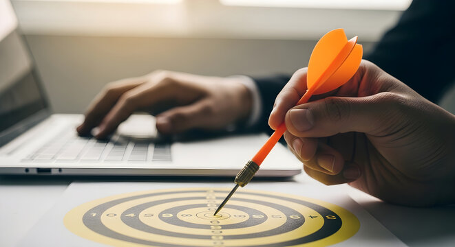 Hands holding dart hitting a target on a table