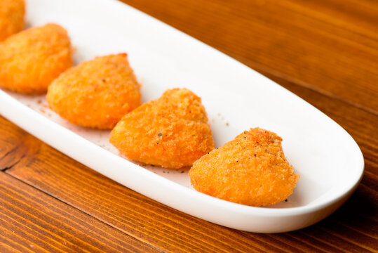 Crispy Japanese fried food platter with refreshing drinks at a cozy Izakaya, authentic pub dining experience, romantic date night with deep-fried appetizers and beer, traditional nightlife scene.