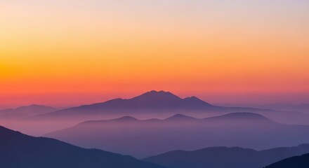 Obraz premium Majestic Mountain Range at Sunrise with Hazy Layers and Vibrant Orange Sky