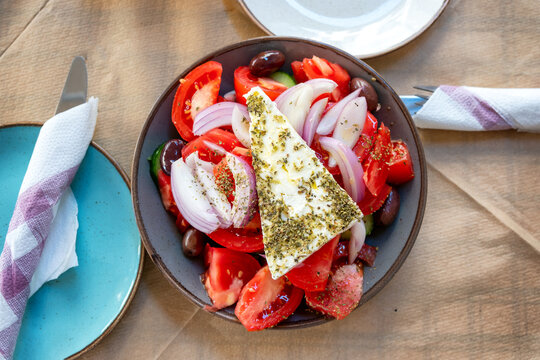 Greek salad with feta cheese slice on a restaurant table.