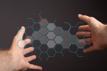 Hands interacting with a futuristic hexagonal graphic, representing concepts like networking and...