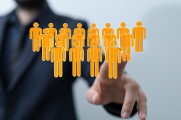 Business man is touching a digital human icons symbolizing a successful team. Teamwork, connection...