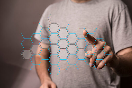 Person interacting with a digital honeycomb graphic, representing technology, innovation, and connection. Concept of dat