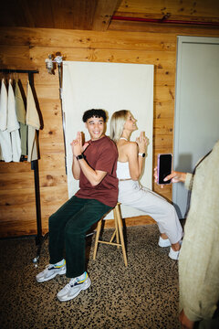 Young adults posing back-to-back with playful expressions in bright casual wear