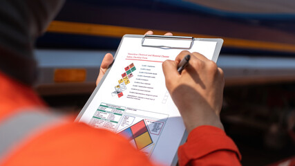 An engineer is checking on chemical hazardous material checklist to verify the safety condition...