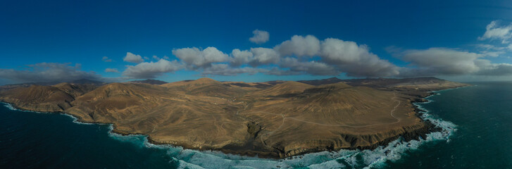 Aerial view of Fuerteventura coastline with dirt road and turquoise Atlantic waters © Hector