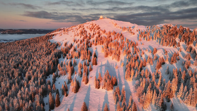 Aerial view of La Dole mountain peak, dusted with snow under a twilight sky, a beacon under soft light, Gingins, Vaud, Switzerland.