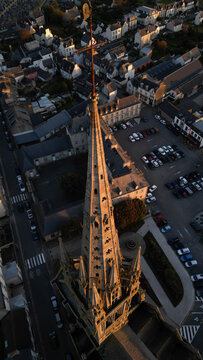 Aerial view of the Kreisker chapel spire piercing the skyline, casting long shadows over the town, Saint-Pol-de-Leon, Bretagne, France.