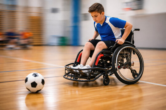 Young Boy Playing Indoor Soccer in Adaptive Sports Wheelchair
