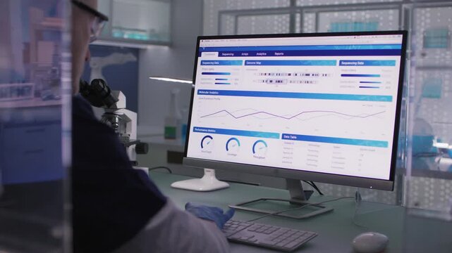 Male scientist or a doctor in protective glove working in a laboratory. Typing on a computer and examining the data
