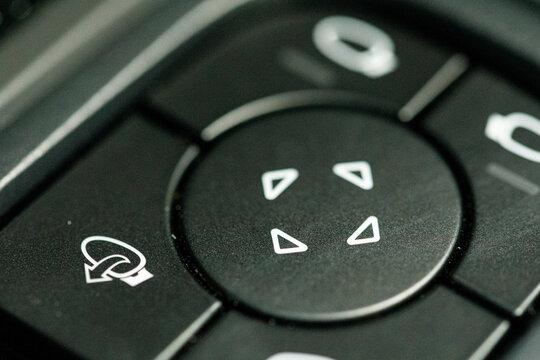 Macro shot of a remote control interface with directional buttons, evoking technology and control.