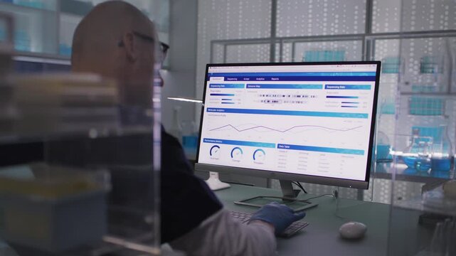 Male scientist or a doctor in protective glove working in a medical research laboratory. Typing on a computer