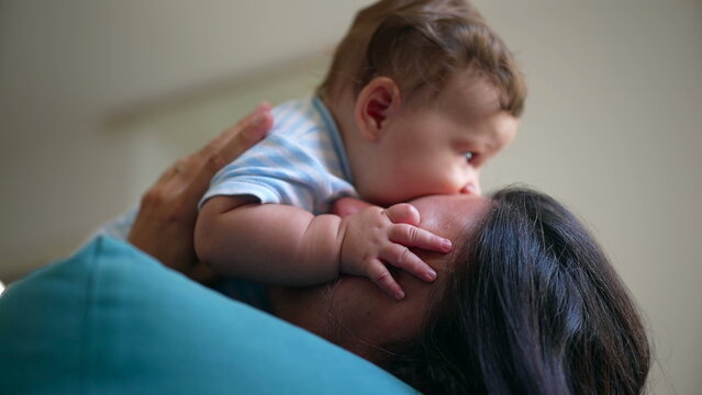 Baby resting on mother&rsquo;s chest, gently biting her cheek in a playful and affectionate moment, parent-child bonding, joy, trust, warmth, comfort, security