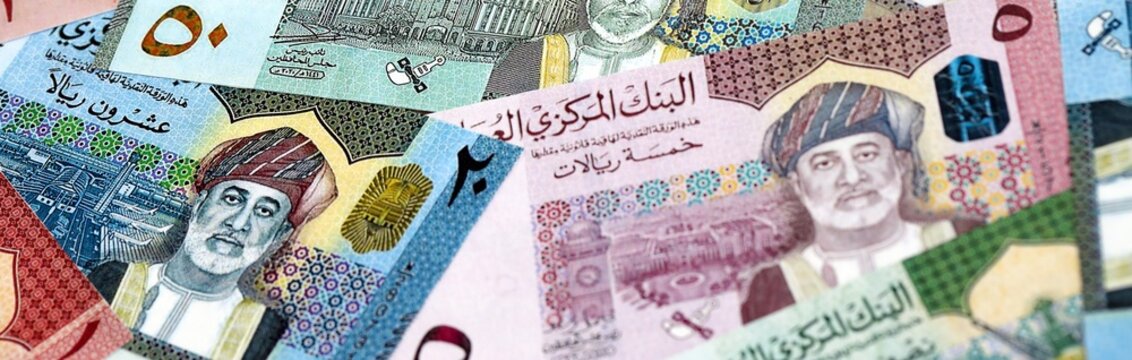 Omani rial money bills pile on table. Oman banknotes of OMR currency close up.
