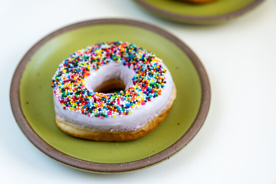 Donut with white icing and colored sprinkles