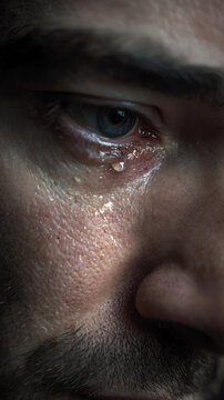 Crying man close up portrait with tear on face, emotional pain, sadness and mental health concept