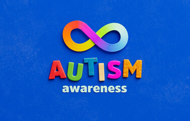 Colorful autism awareness design with rainbow infinity symbol on blue background, representing...
