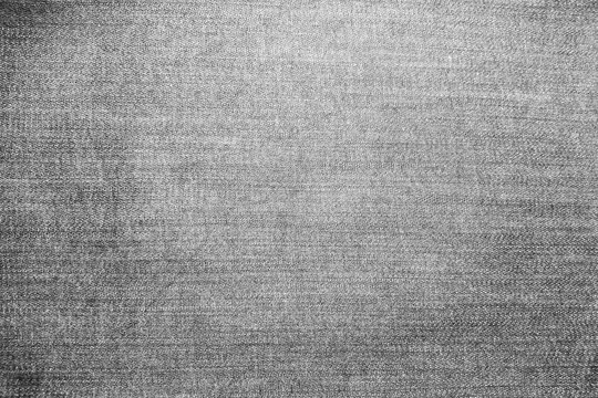 High-quality close-up of grey denim fabric texture with natural faded effect. Detailed cotton textile weave background for fashion, apparel, and industrial design concepts.