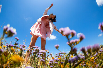 Happy woman enjoying nature outdoors among flowers. Outdoors.