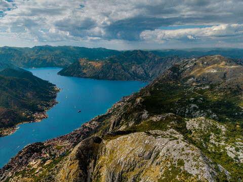 Aerial view of a dramatic fjord cutting through rugged mountains, the deep blue waters contrasting with the verdant slopes, Kotor, Kotor Municipality, Montenegro.
