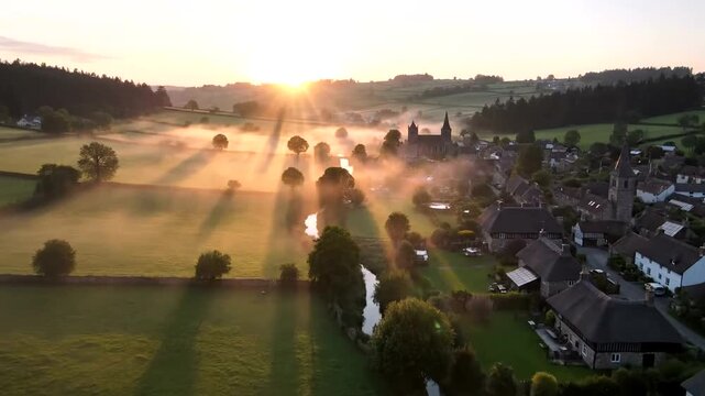 aerial view of a foggy rural town at sunrise.