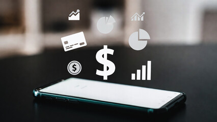 A smartphone displays financial icons floating above a dark table. Money and charts appear digital.