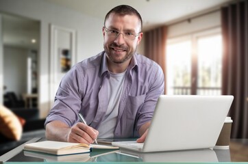 Fototapeta premium Happy cheerful businessman working on a laptop in office.