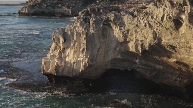 4k 60p footage of the rocky coastline near Waenhuiskrans Cave, Arniston. Towering cliffs meet ocean waves in Overberg seascape, Western Cape, South Africa. Ideal for nature and travel visuals.