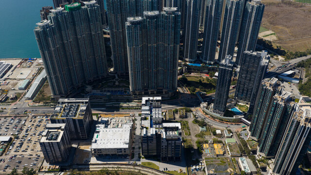 Aerial view of towering skyscrapers casting long shadows over the urban landscape near Wan Po Road, Data Center, Tseung Kwan O, New Territories, Hong Kong.