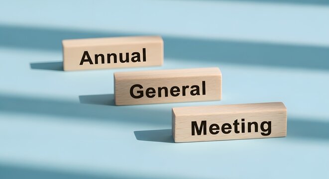 Annual General Meeting Concept: Wooden Blocks on Blue Background
